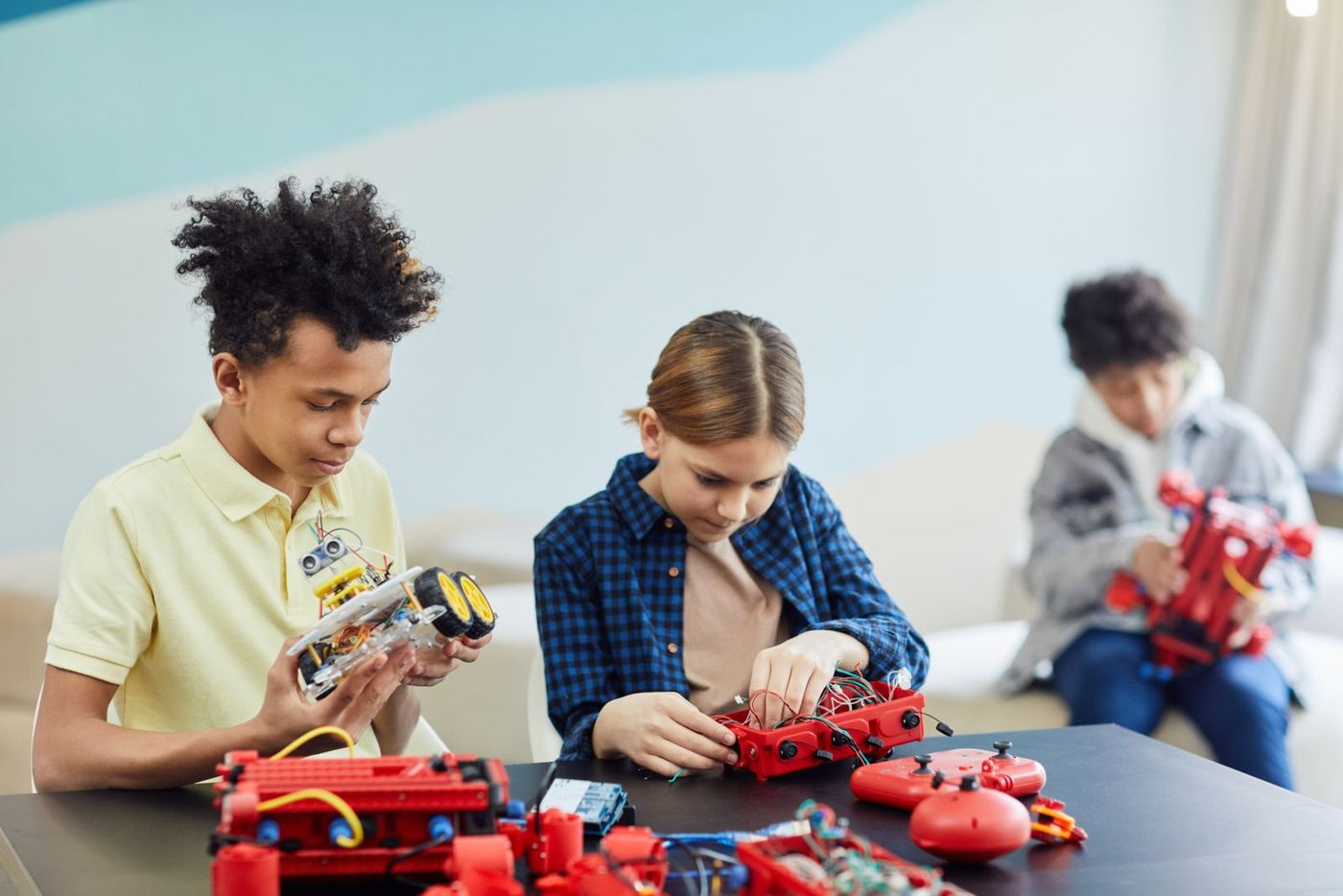 Young learners building and wiring robot cars
